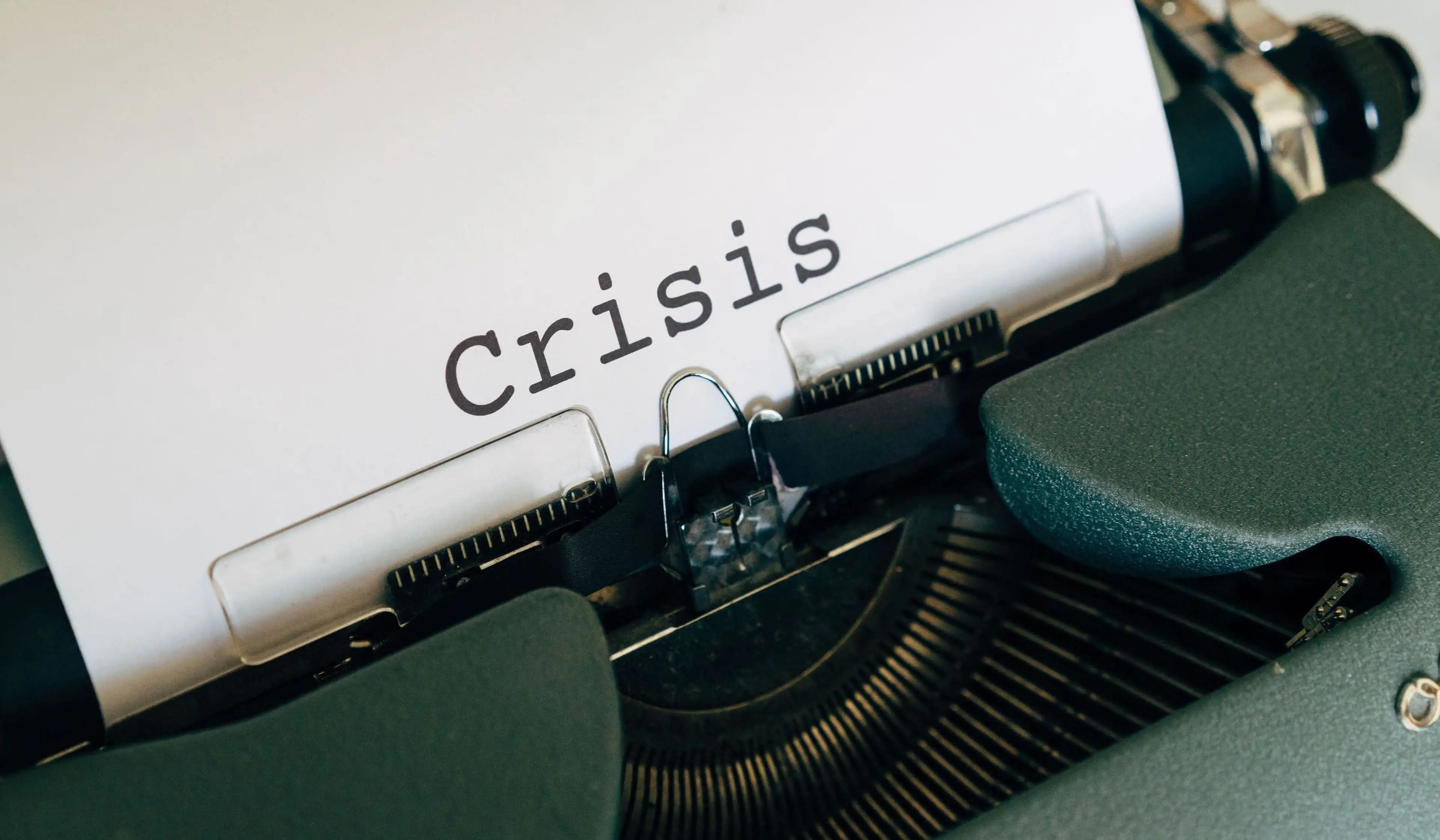 Hvidt ark i en skrivemaskine med ordet "Crisis" skrevet på.