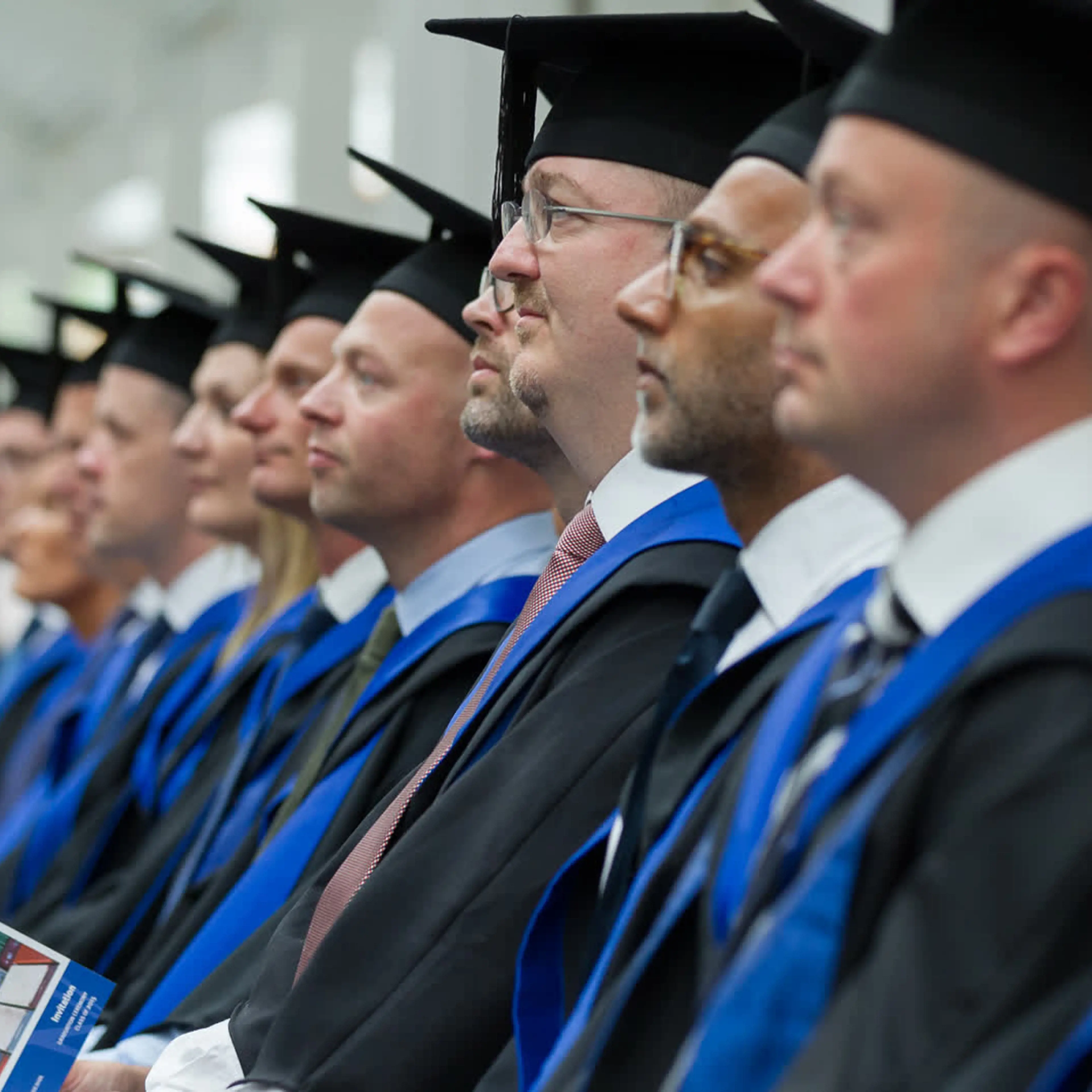 Blue MBA participants sitting in their robes on graduation day