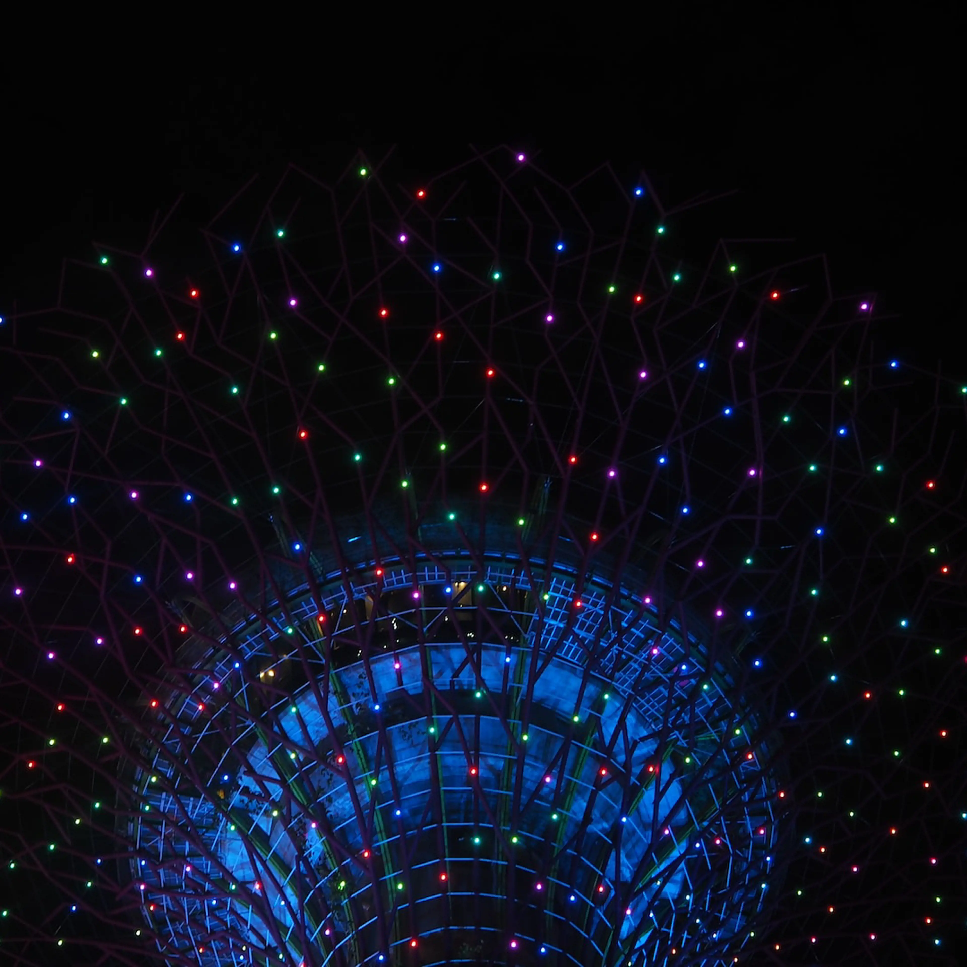 Tower in the dark seen from below with colorful lights