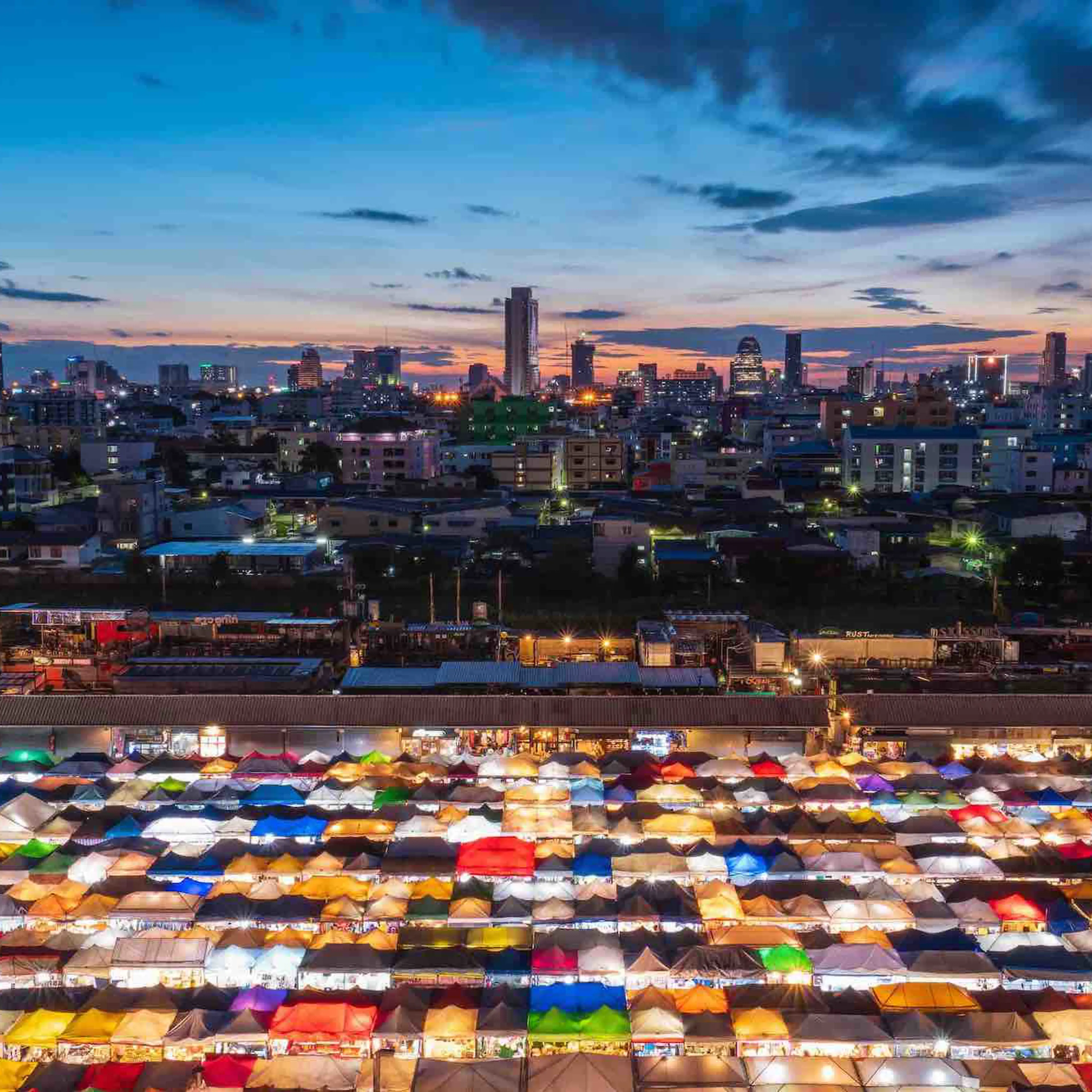 Illuminated colorful tents and the skyline of a big city seen from above